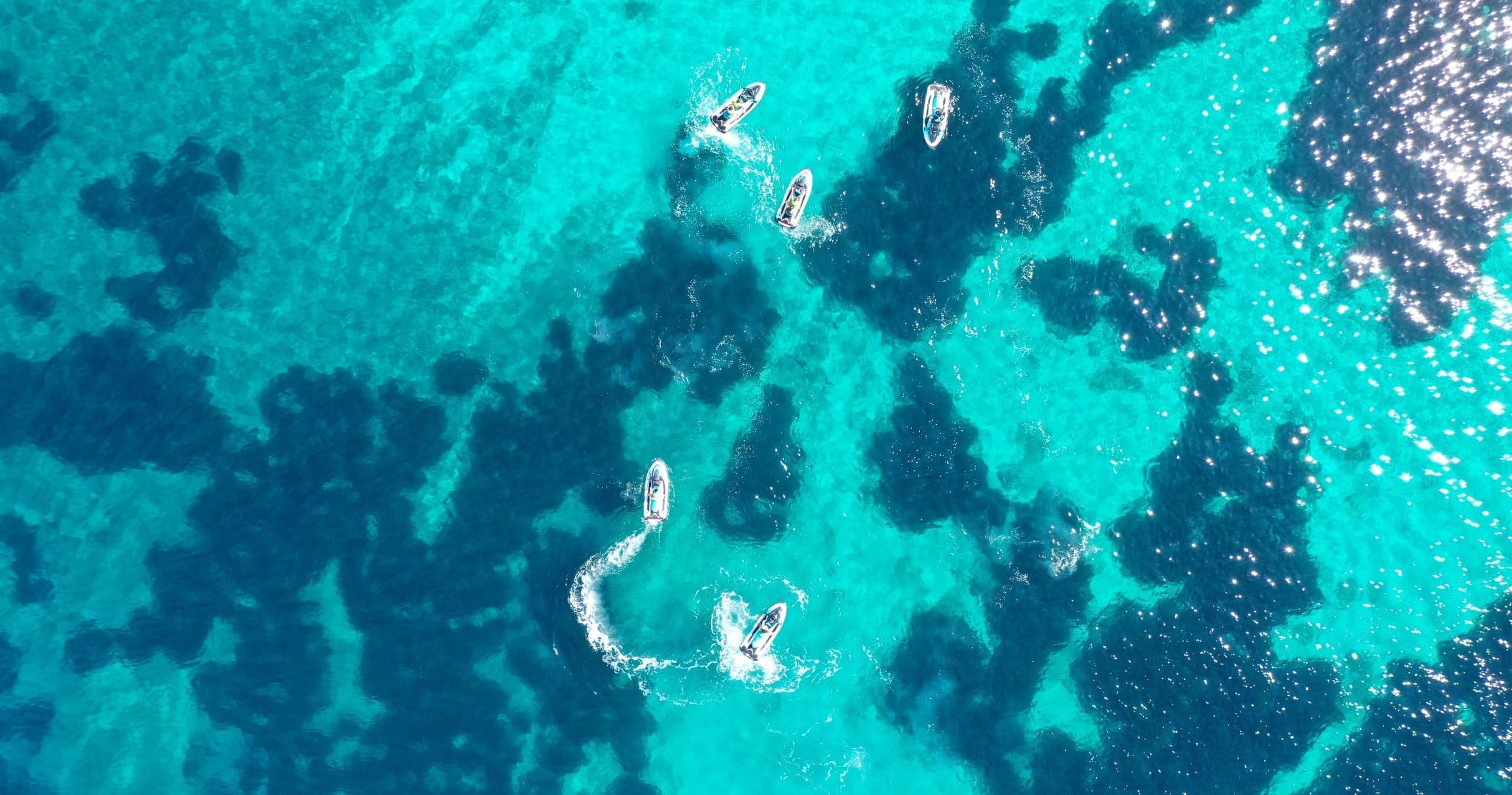 Aerial jet skis over turquoise Mediterranean waters and reefs
