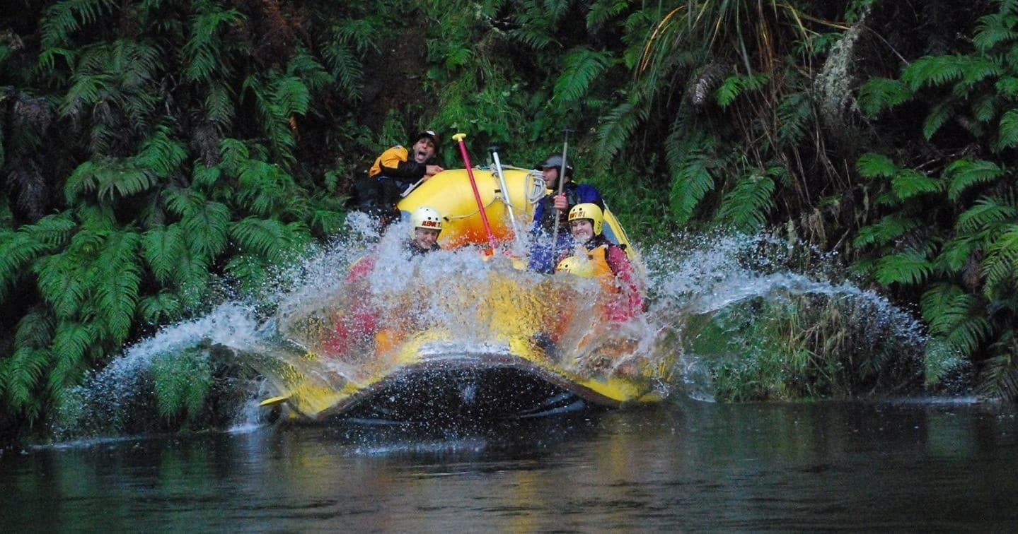 Whitewater rafting through lush forest gorge with splash action