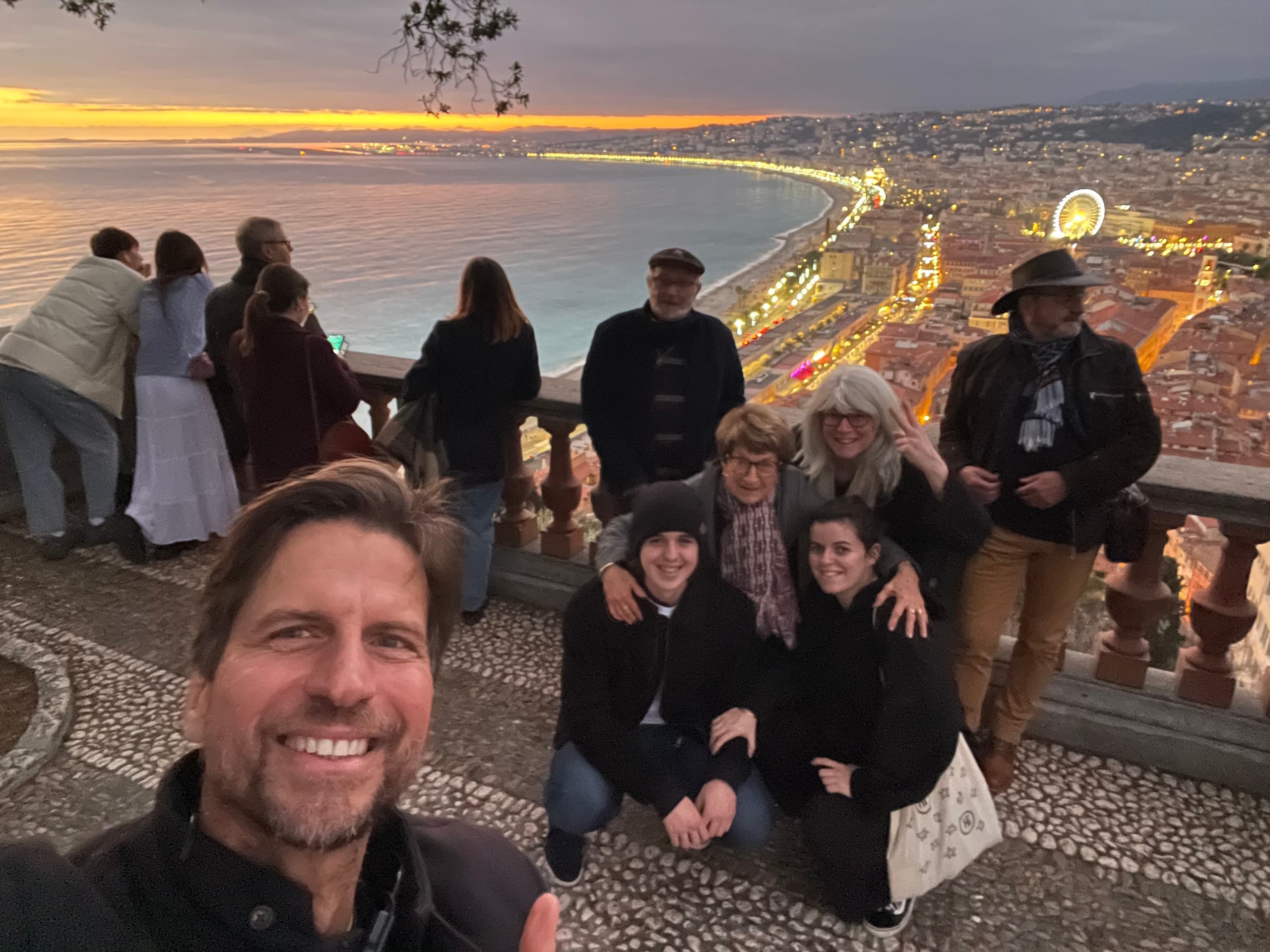 Group taking sunset viewpoint selfie overlooking Nice coastline promenade