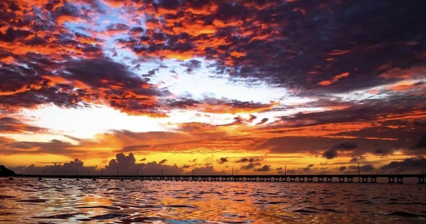 Sunset over ocean pier during scenic coastal cruise at dusk