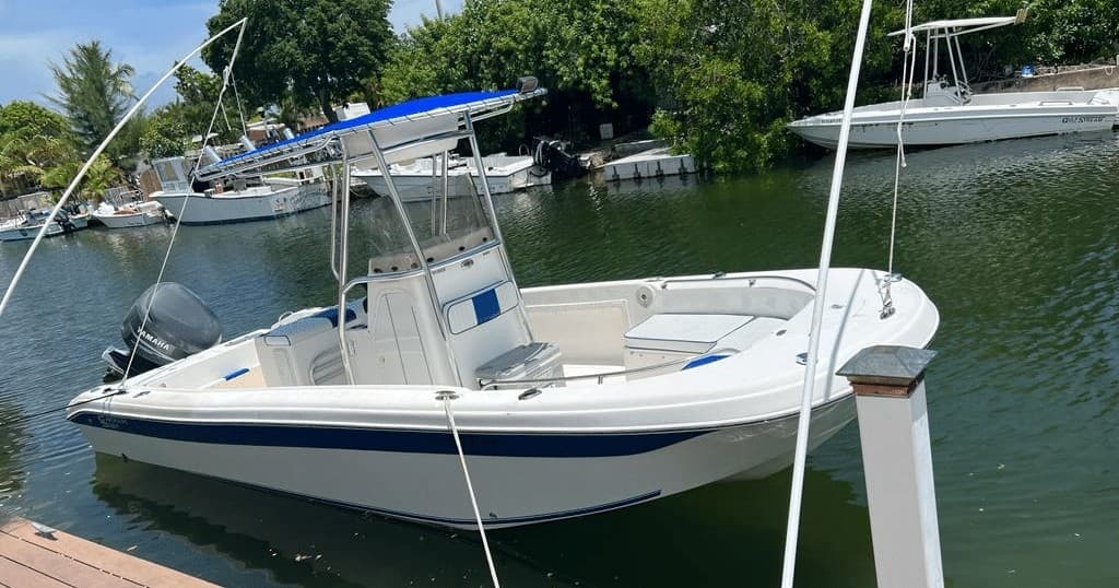 Center-console fishing boat docked in coastal inlet, mild waves