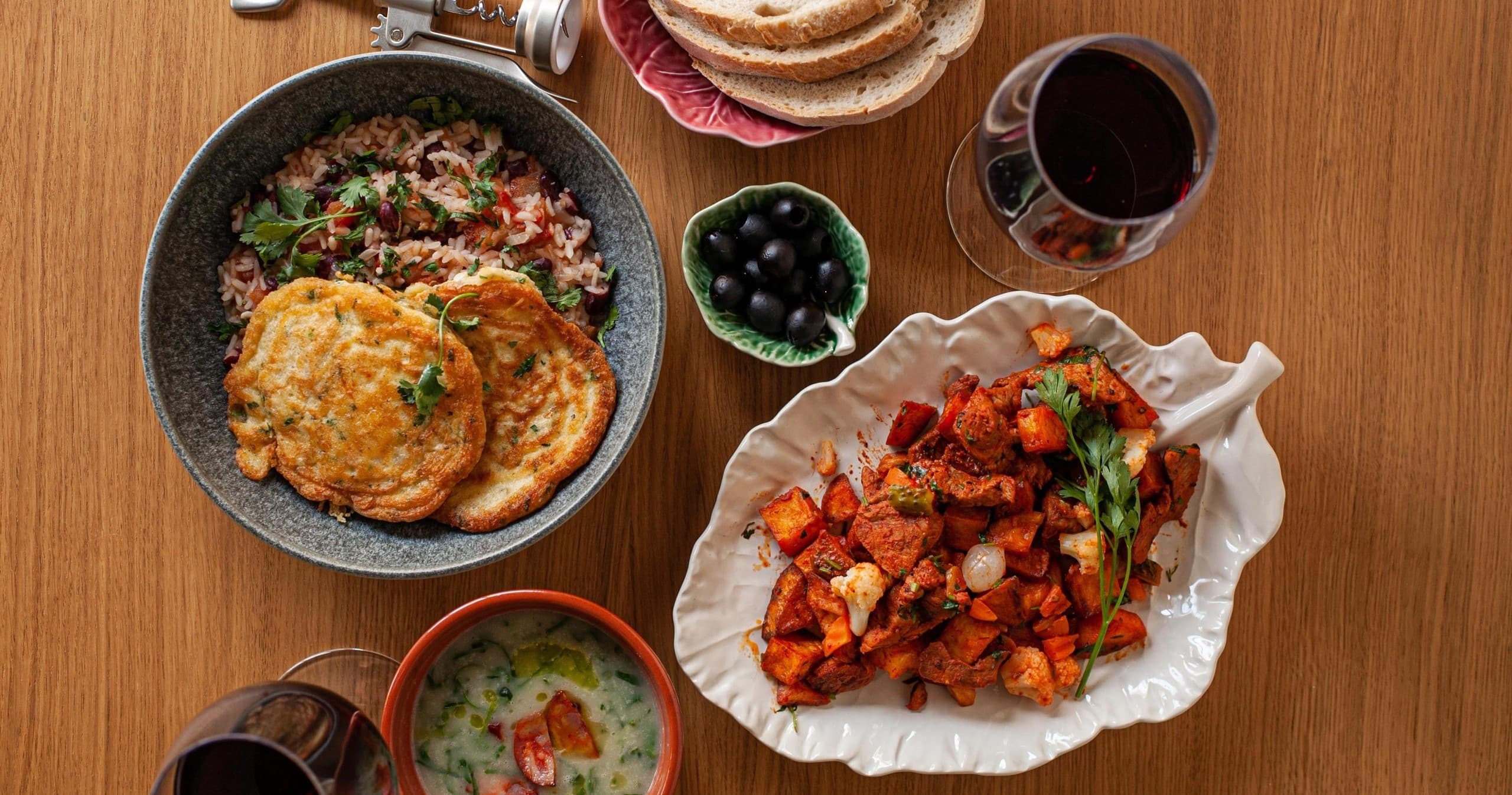Hearty Portuguese meal plates served on wooden table in Lisbon kitchen