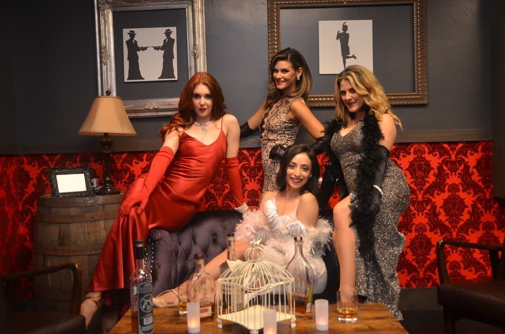 Four performers posing in a theatrical lounge at an indoor Vegas show