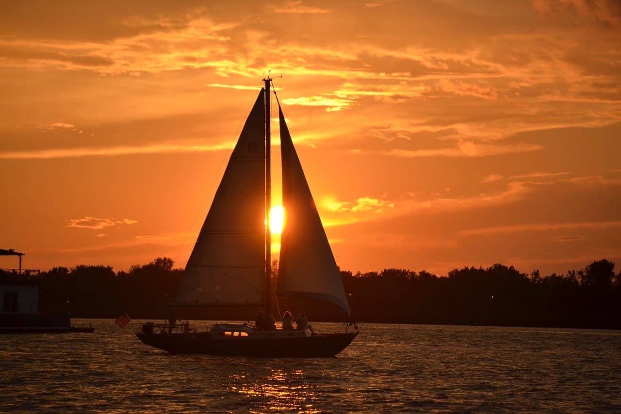 Sailboat silhouette at sunset over New York Harbor, sailing