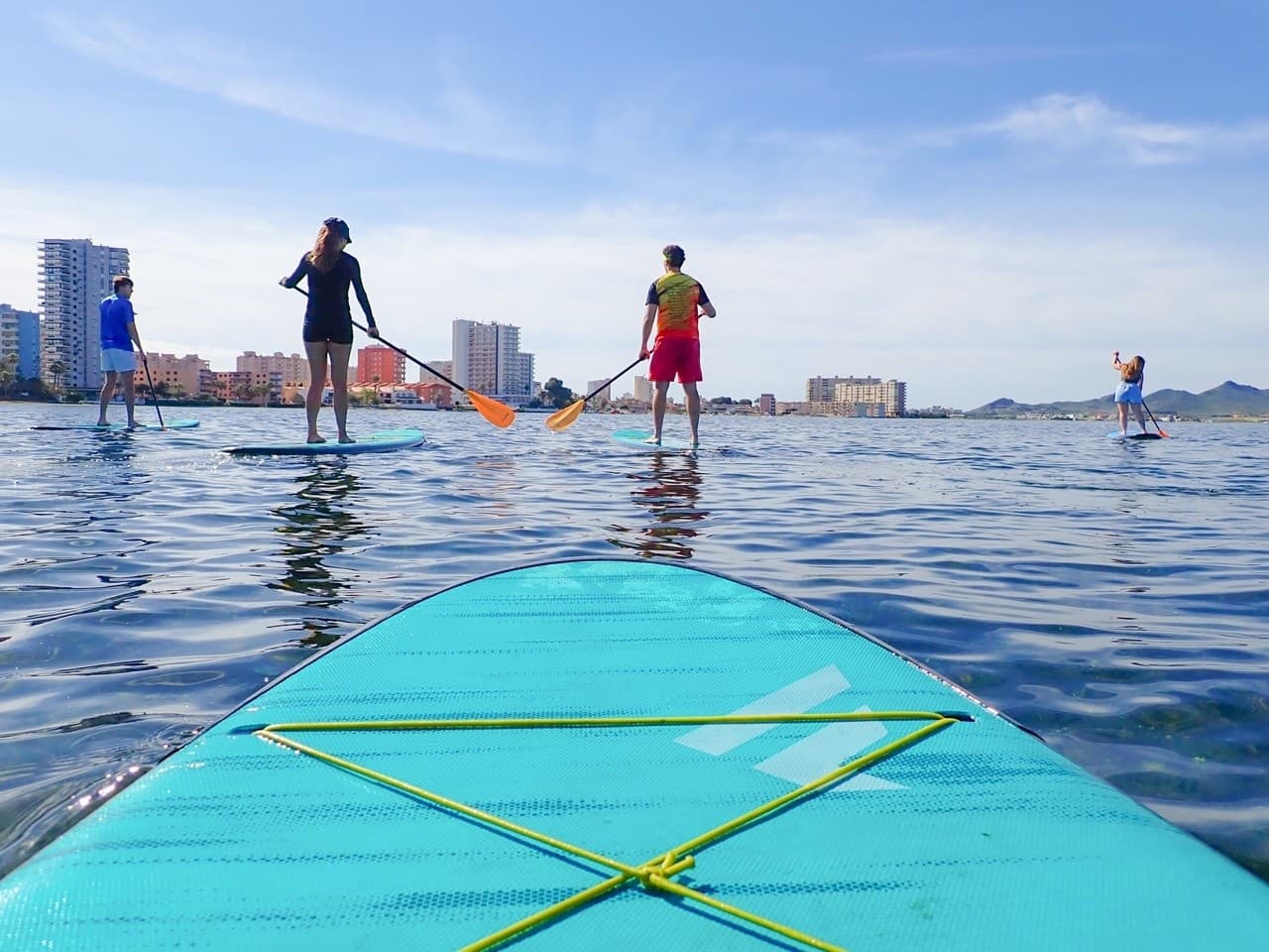 Paddleboards lined on sandy beach with instructors preparing lesson