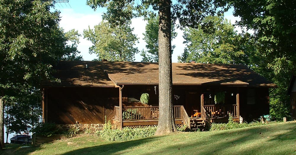 Rustic lakeside cabin porch among trees at Eddy Bay Resort