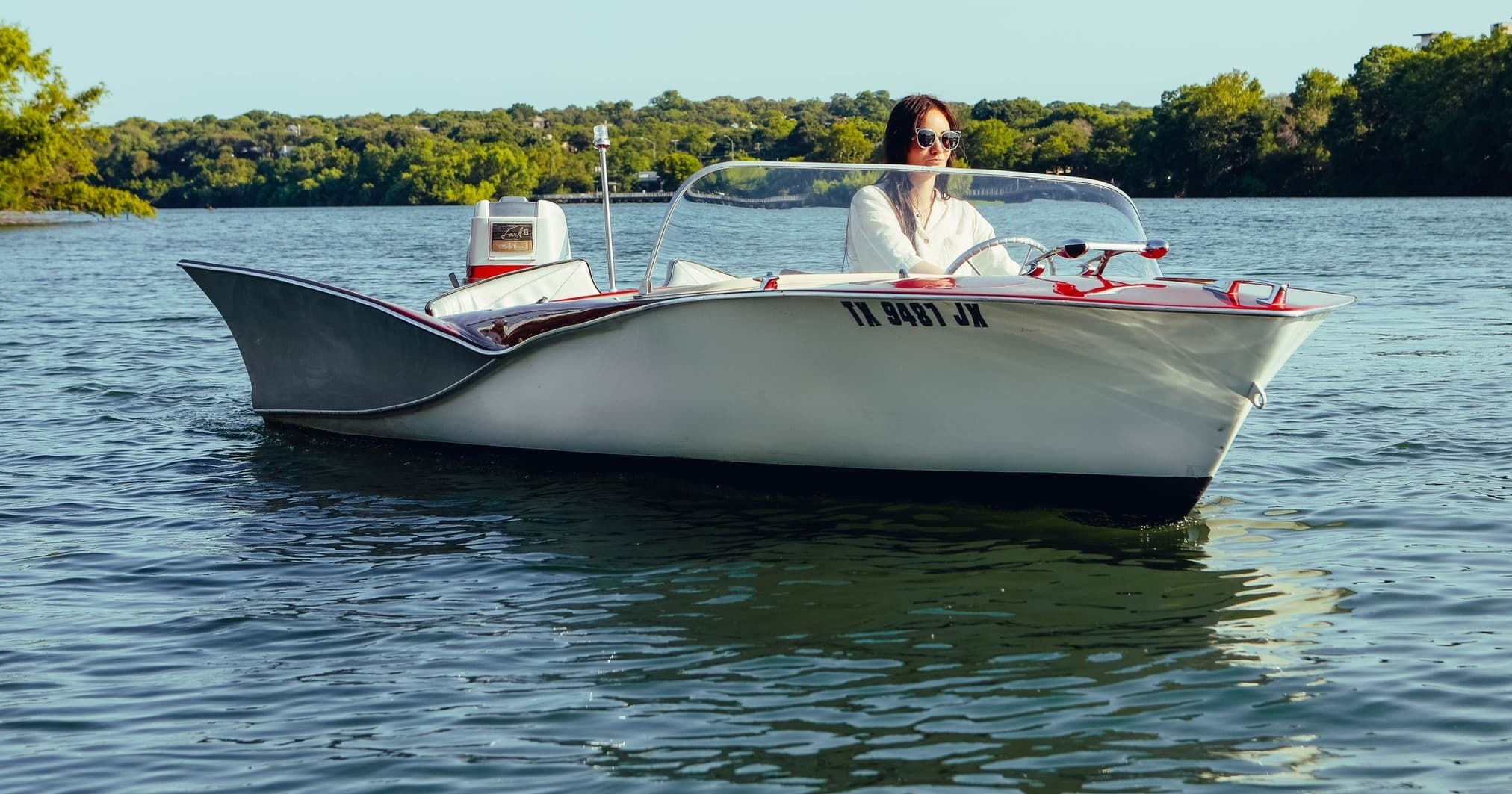 Classic bowrider boat cruising Lady Bird Lake with skyline