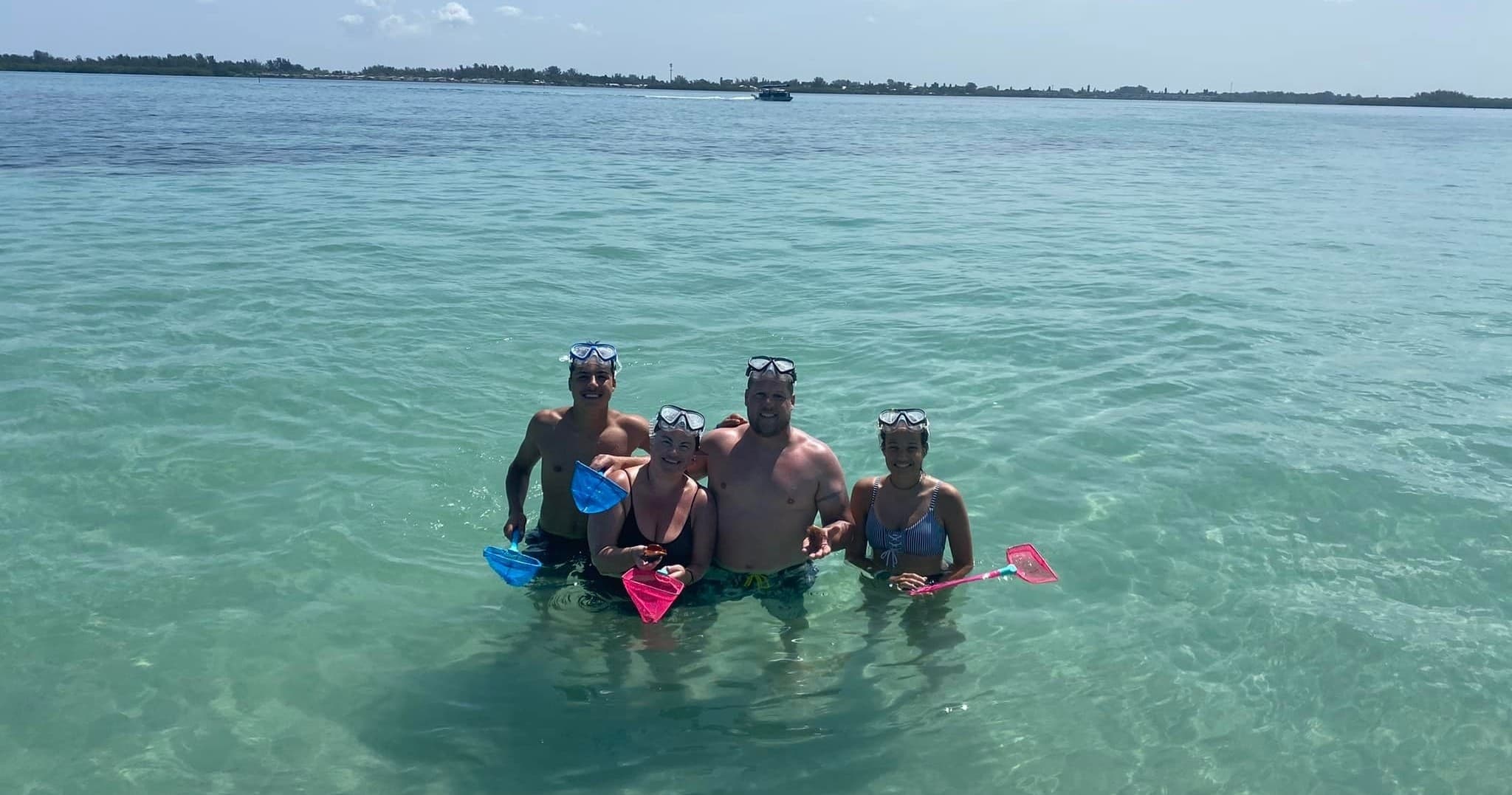 Snorkelers grouped in shallow turquoise water on marine tour