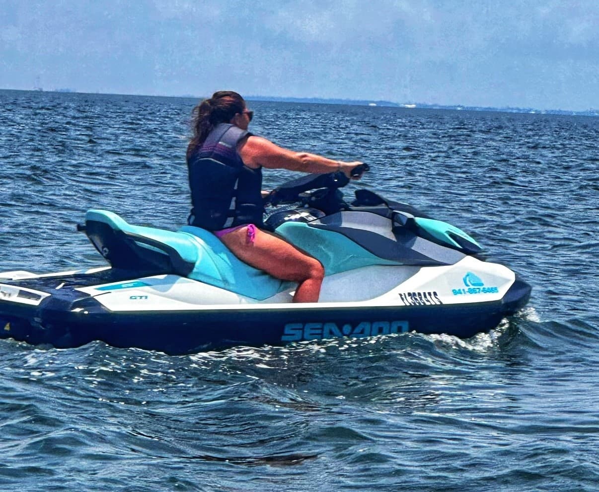 Solo rider on a jet ski cruising open ocean waters near coastline