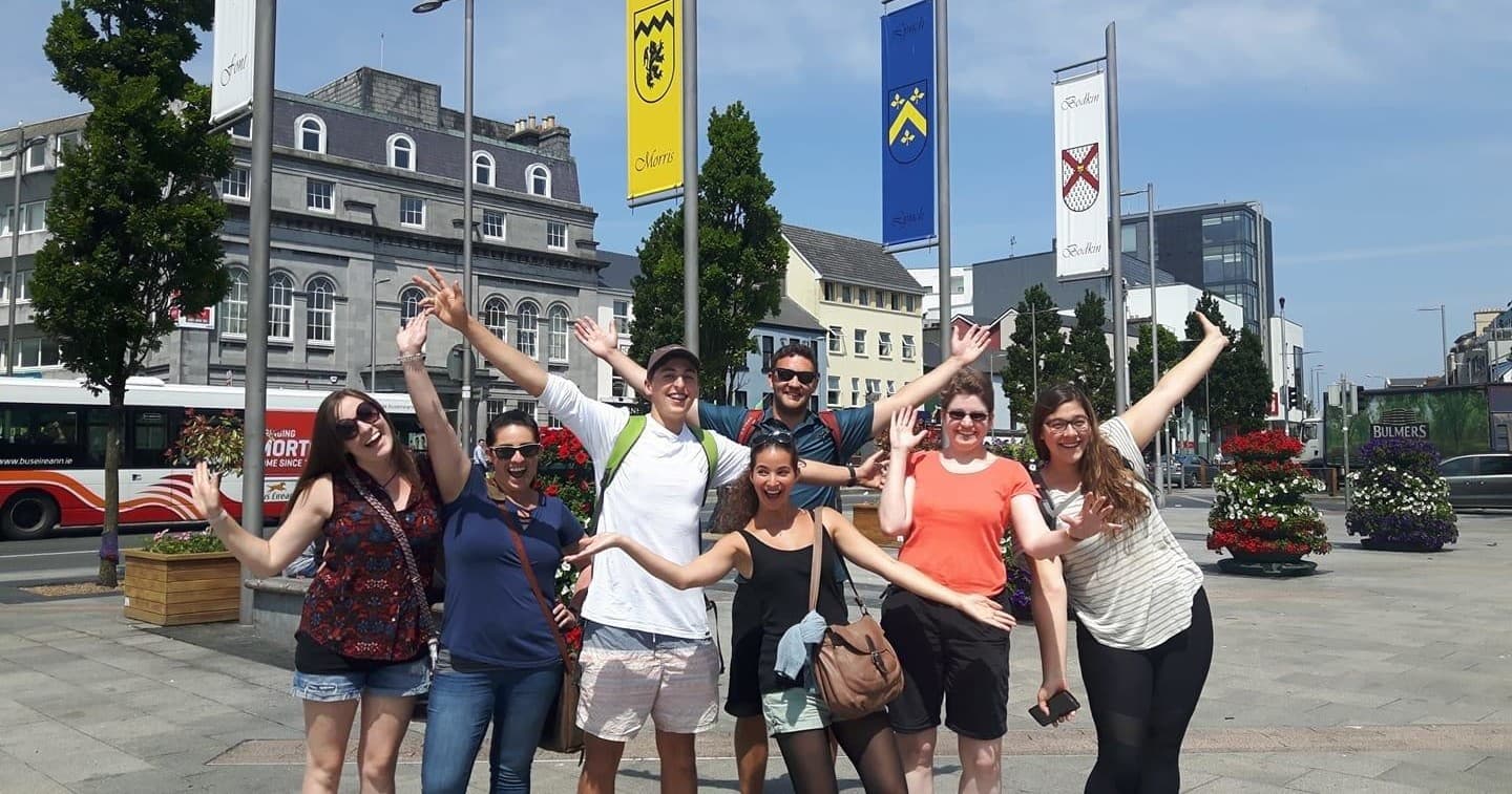 City walking tour group celebrating in sunny town square