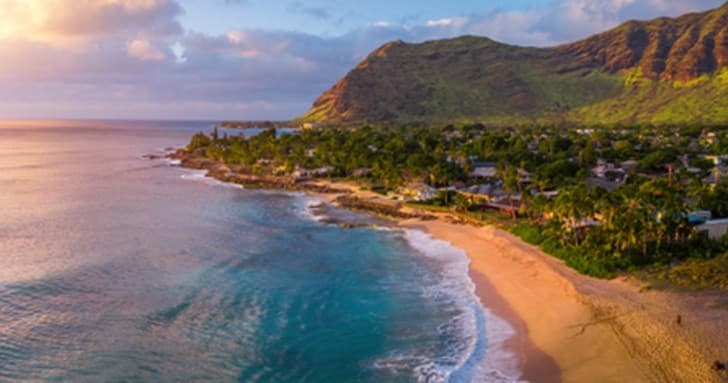 Aerial view of tropical beach coastline and sunset