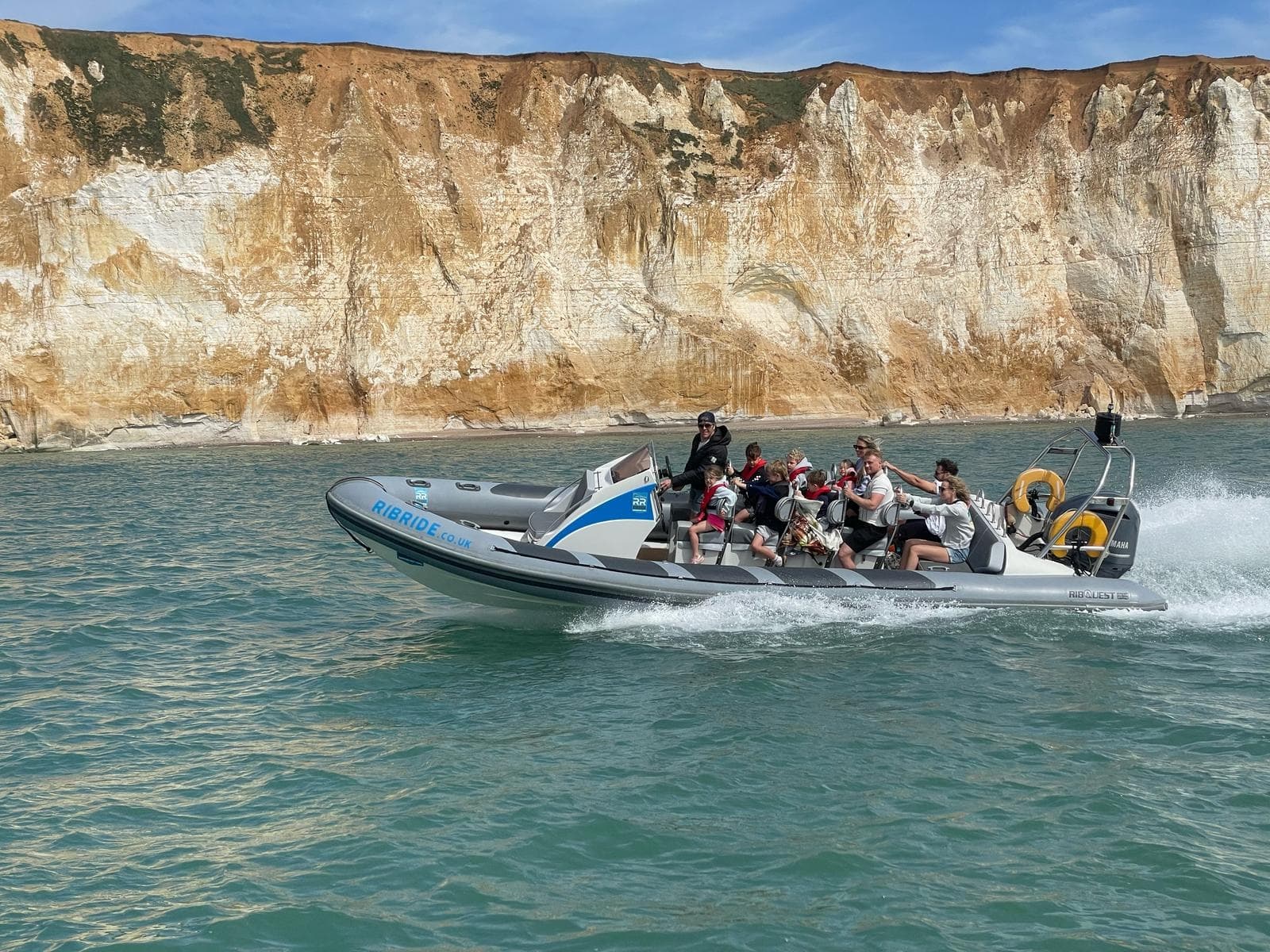 RIB adventure with passengers cruising along cliffs