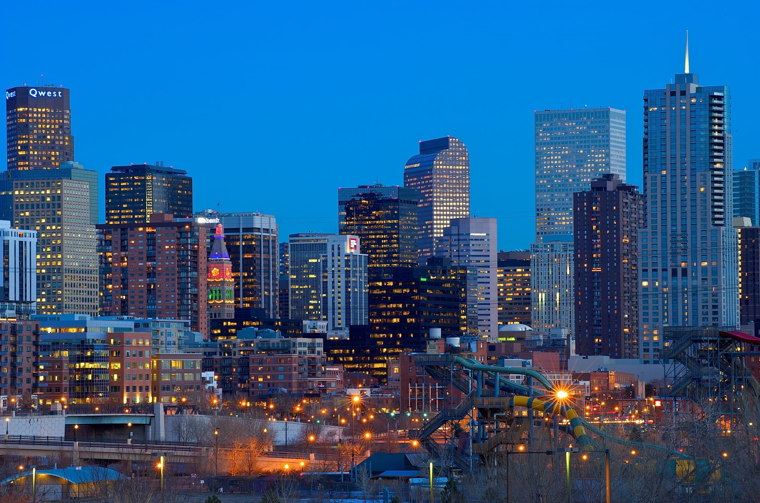 Downtown city skyline at dusk with illuminated buildings, urban vista