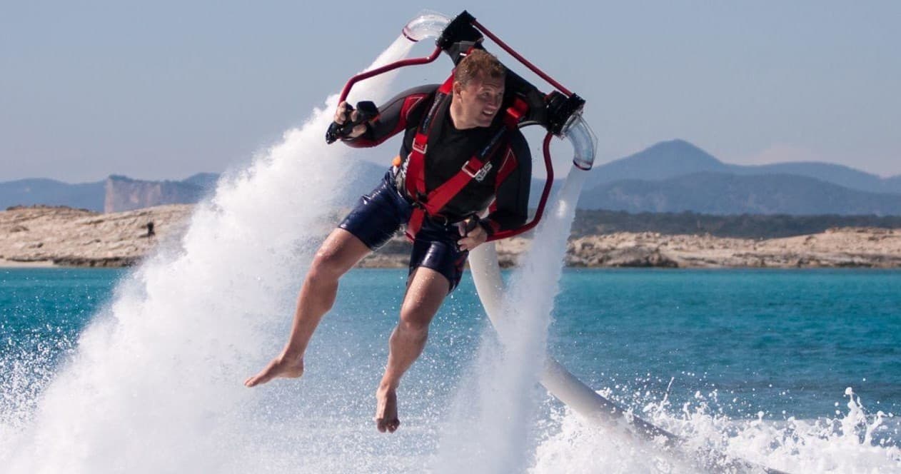 Hydrojet rider propelled above sea spray during coastal water activity
