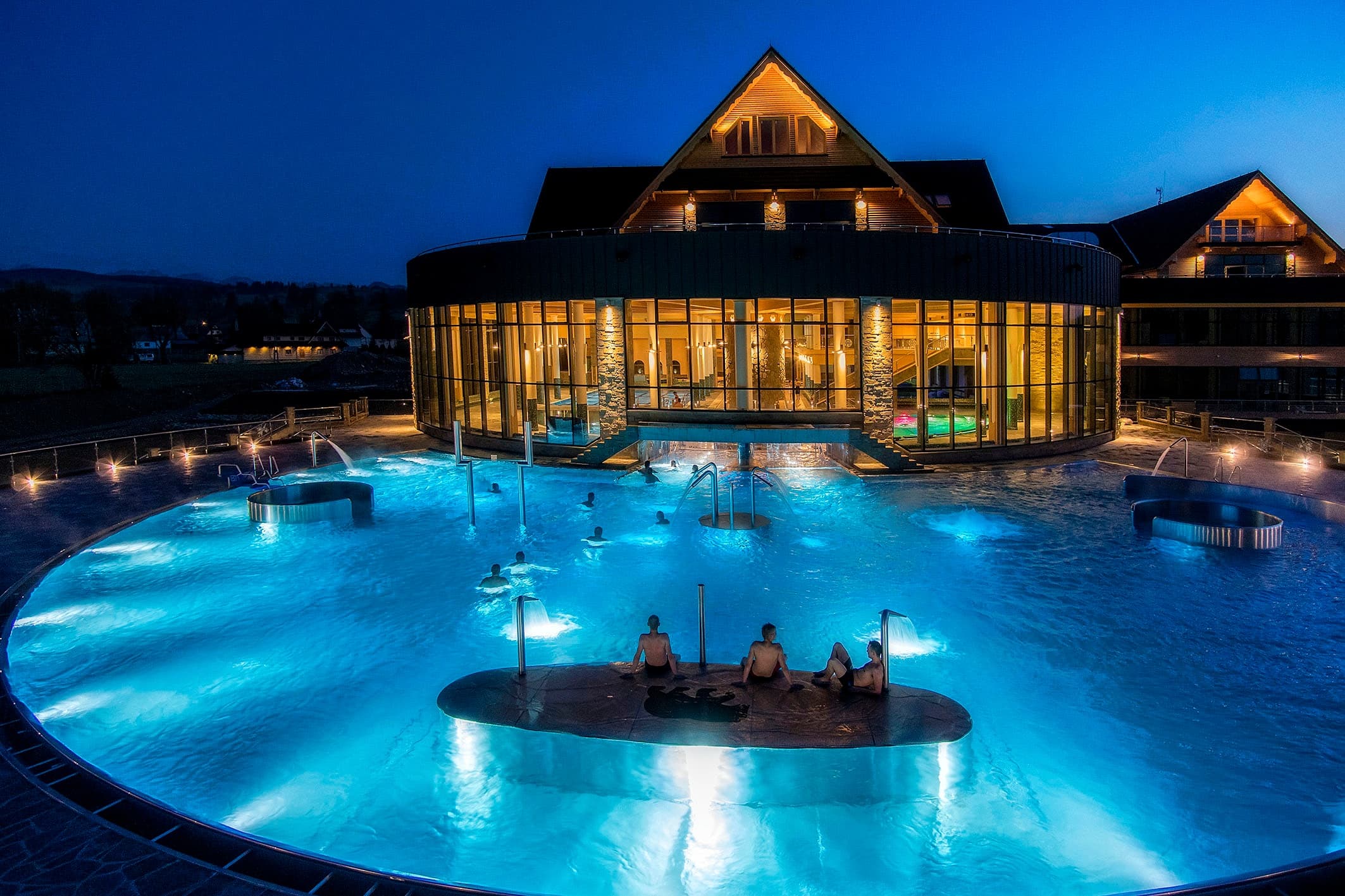 Evening thermal pools and spa soaking in outdoor resort lights