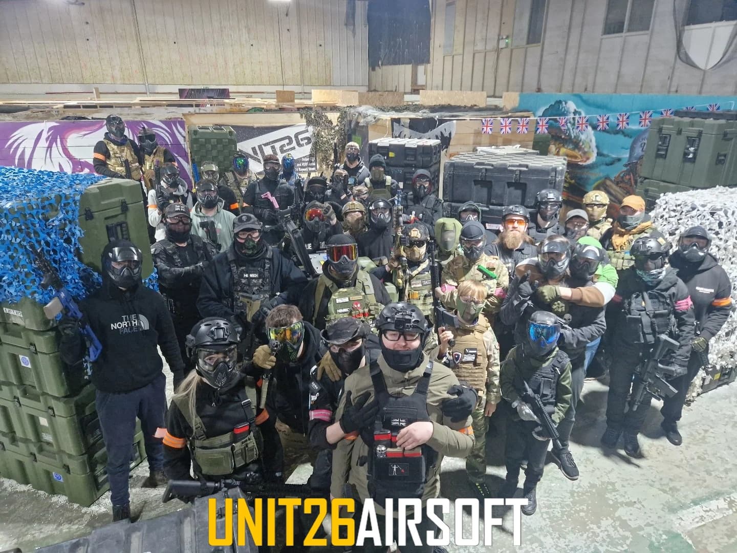 Group of airsoft players posing in indoor urban combat arena