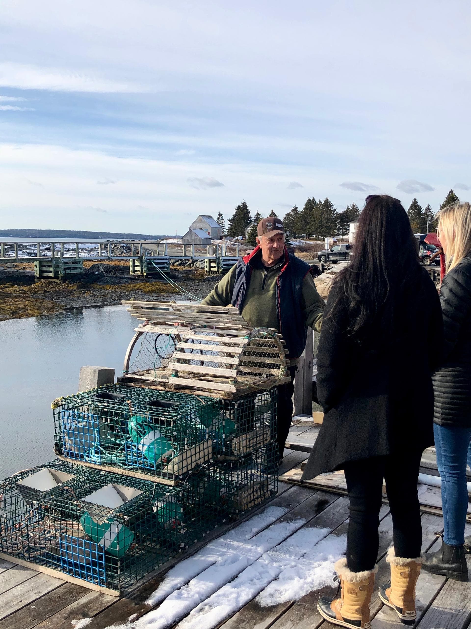Harbor dock crew demonstrating lobster traps during cold-weather tour