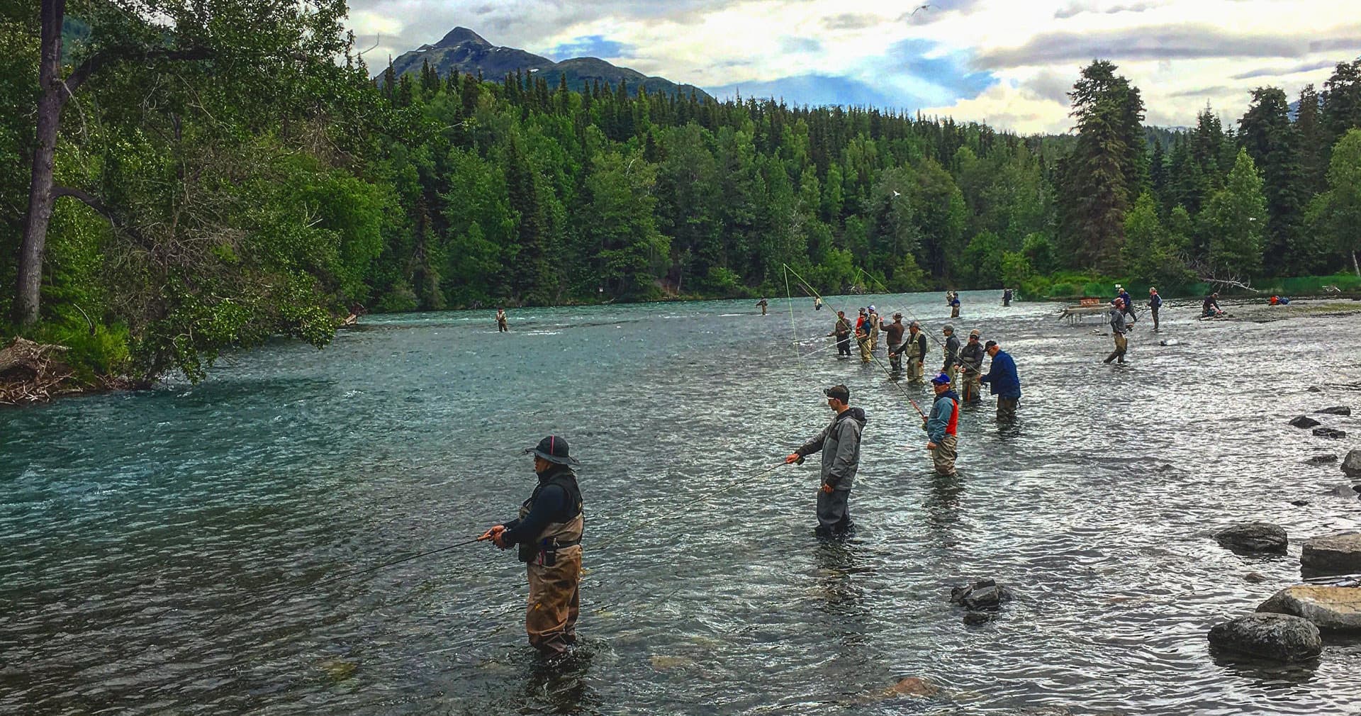 Guided river fishing group wading in clear mountain river