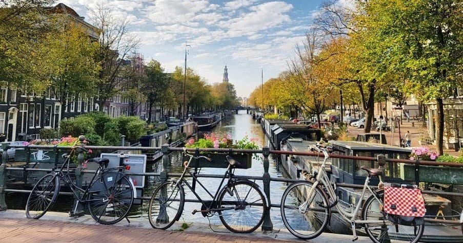 Bicycles on Amsterdam canal bridge, scenic autumn city viewpoint