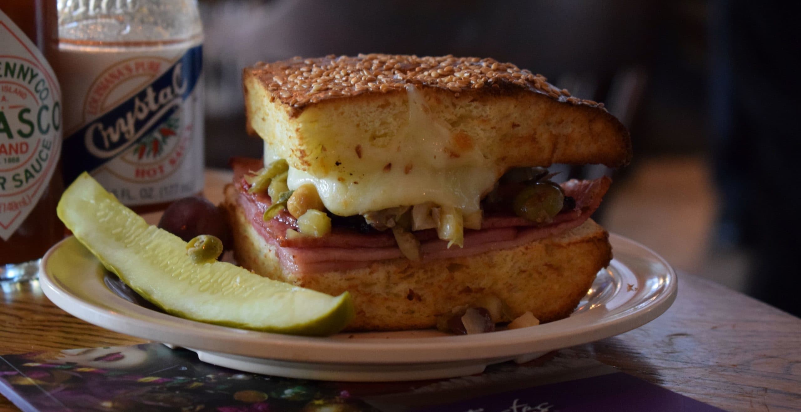 Grilled sandwich with pickle on plate in cozy diner