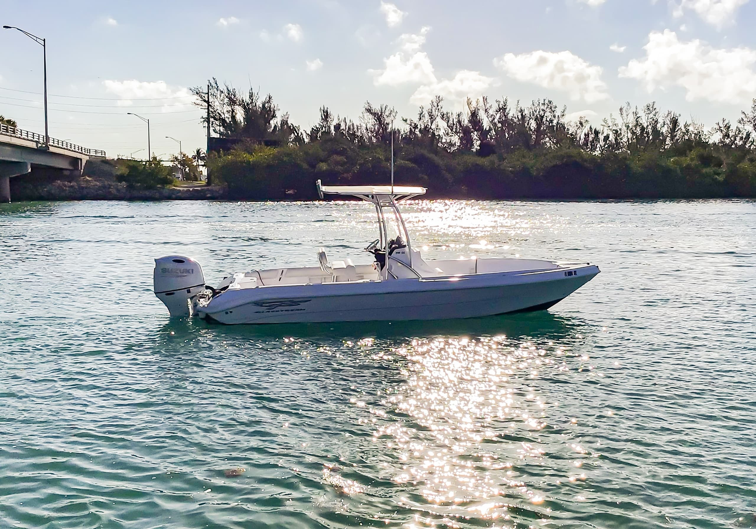 Small leisure boat anchored in sunlit inlet with sparkling water