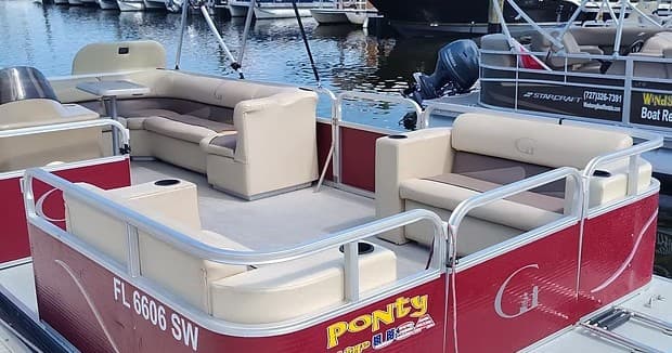 Pontoon boat interior seating docked at marina, vinyl lounges