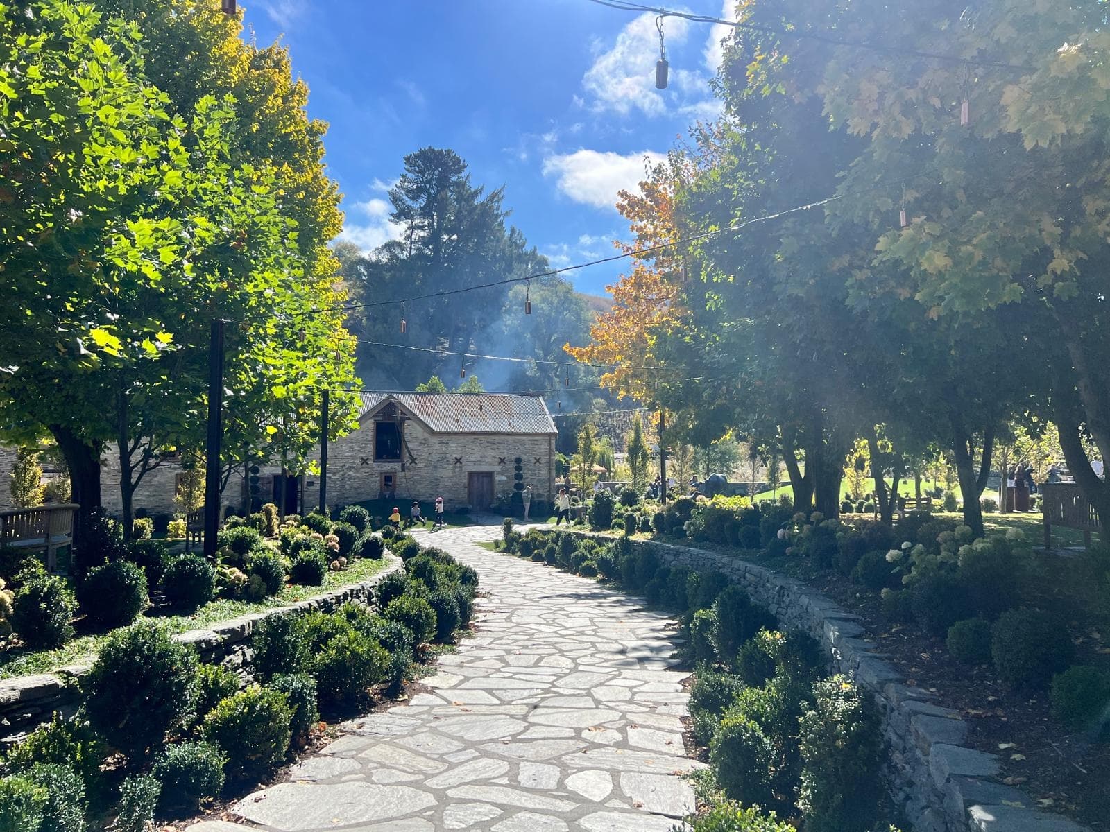 Sunlit stone garden path through manicured outdoor estate