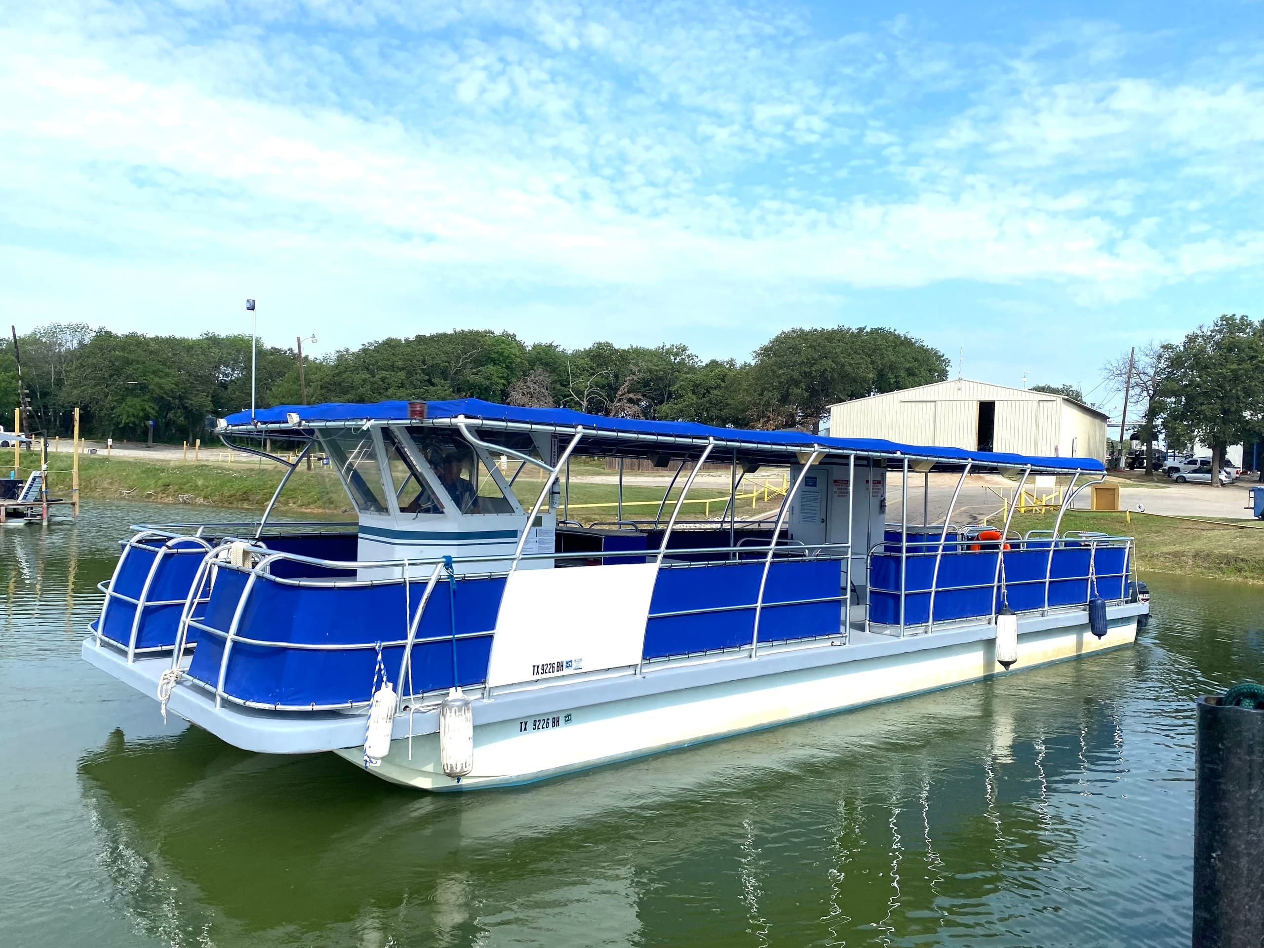 Blue pontoon boat moored on scenic lake near Eagle Point Marina