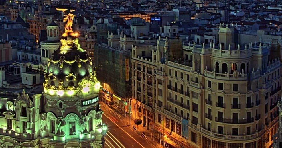 Twilight cityscape of Madrid Gran Vía with illuminated Metropolis building
