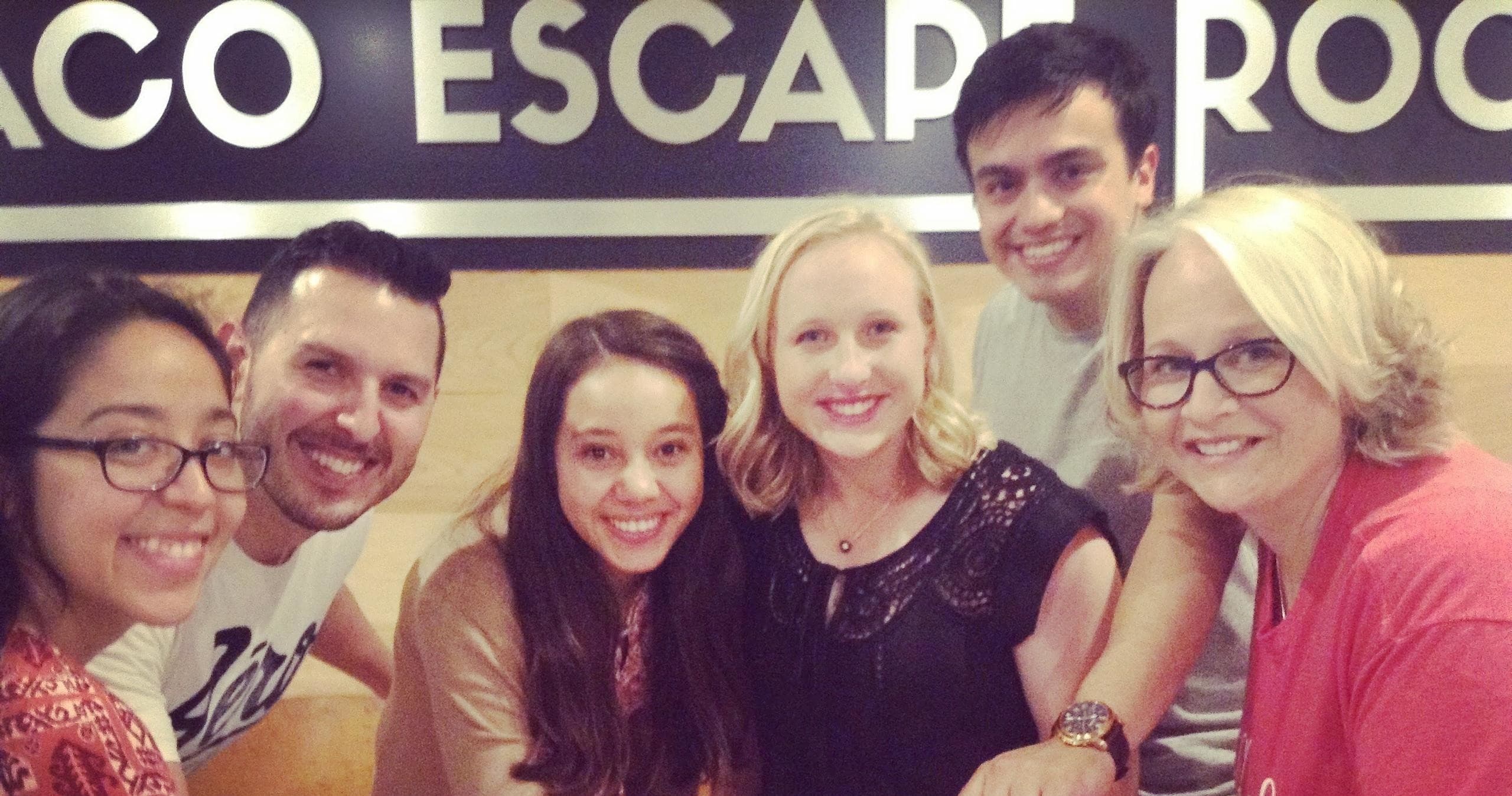 Happy escape room team selfie smiling inside Waco Escape Rooms lobby