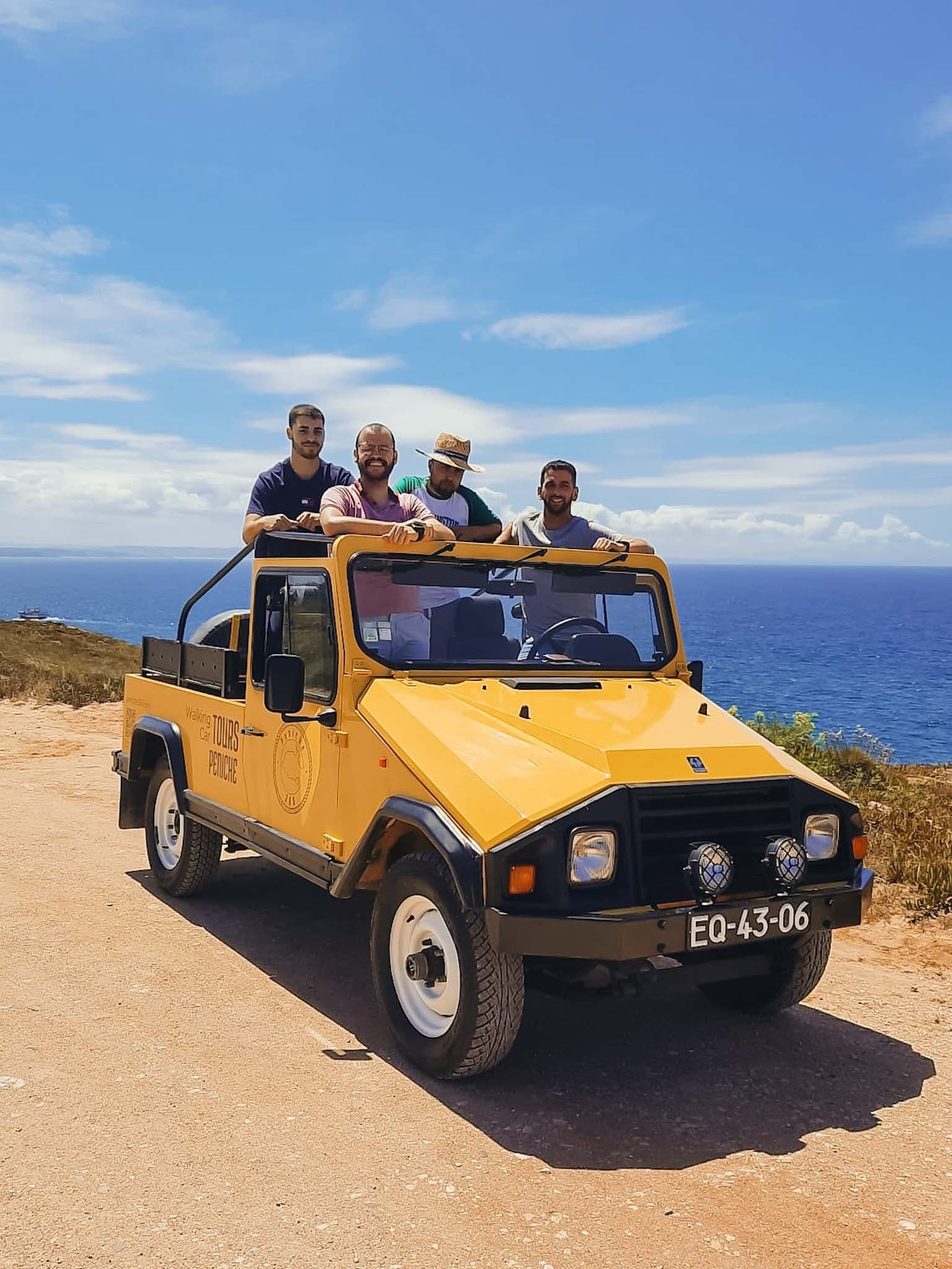 Open-top vintage jeep tour with friends along seaside road
