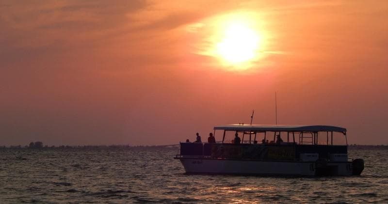 Sunset cruise boat silhouetted on Gulf waters off Fort Myers