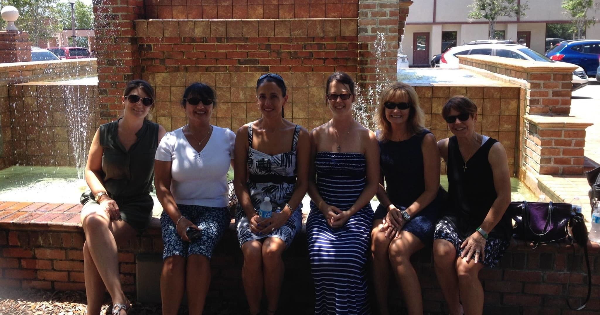 Friends seated by downtown fountain during Panama City sightseeing