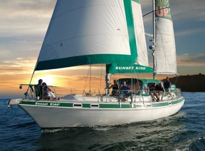Sunset Kidd sailing charter gliding at sunset with crew aboard