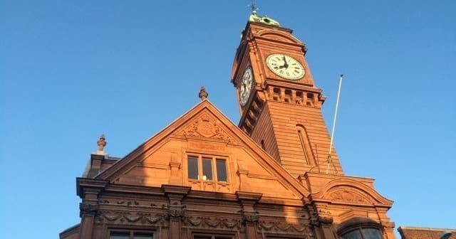Historic red clocktower building facade under blue Dublin sky
