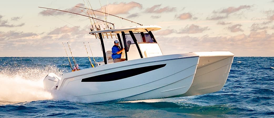 High-speed center console boat powering over ocean waves at sunset