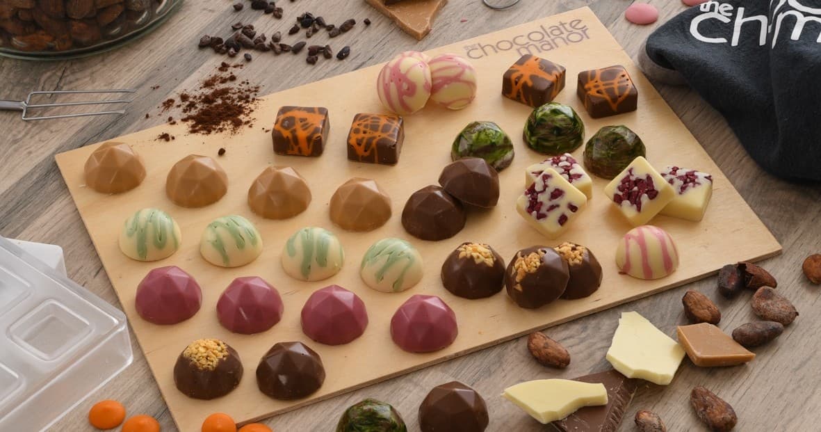 Assorted gourmet chocolate pralines on wooden board