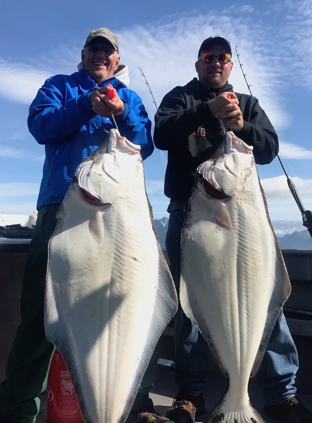 Two anglers holding giant halibut on deck after Homer Alaska trip