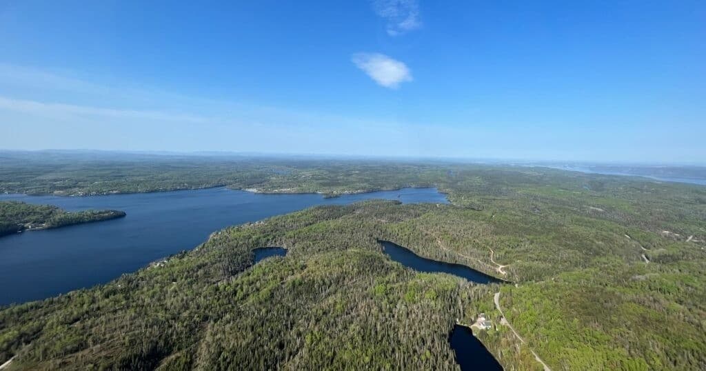 Bird's-eye helicopter view over lakes and dense forested islands