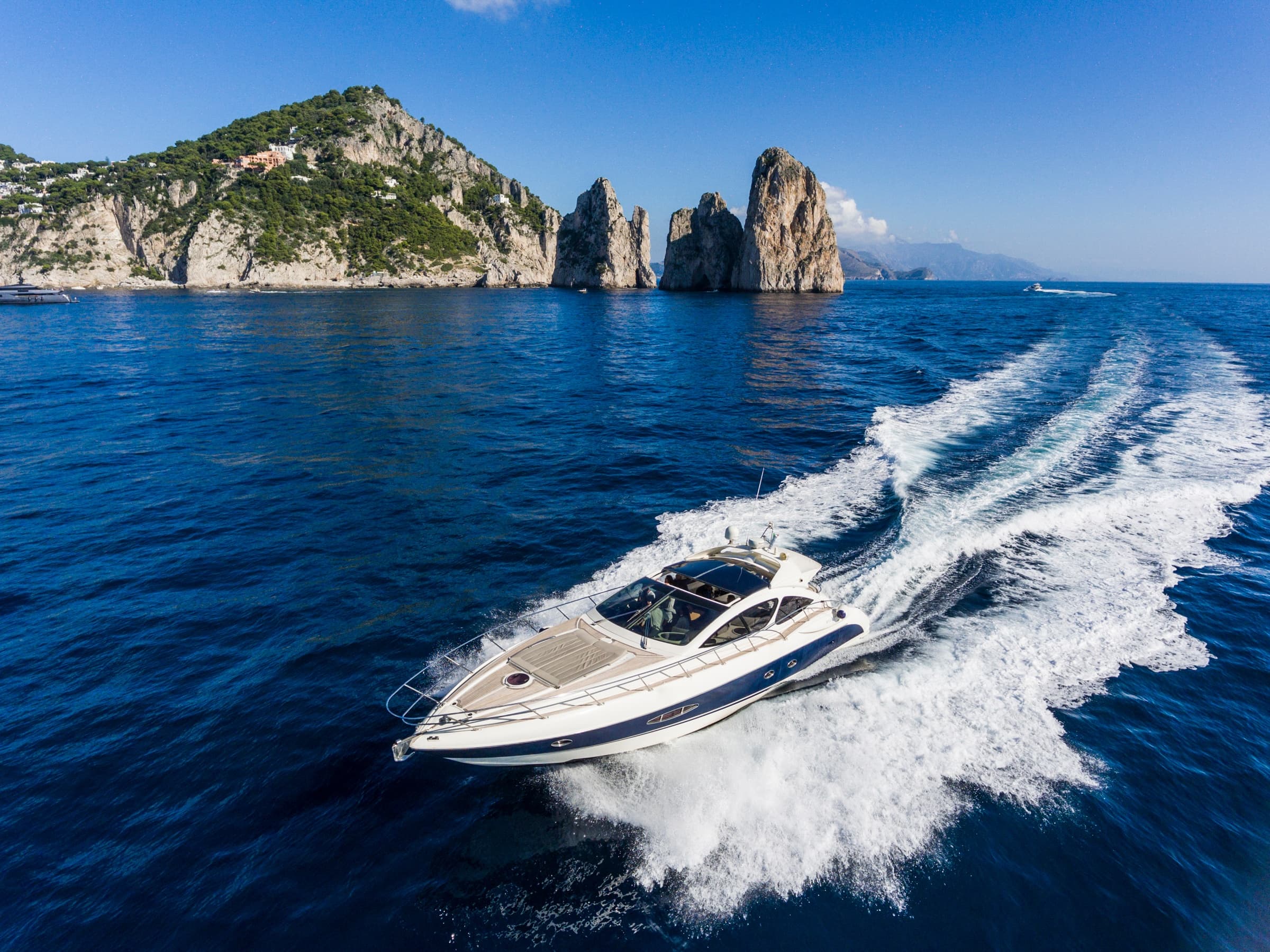Speedboat slicing azure water near Mediterranean island coast