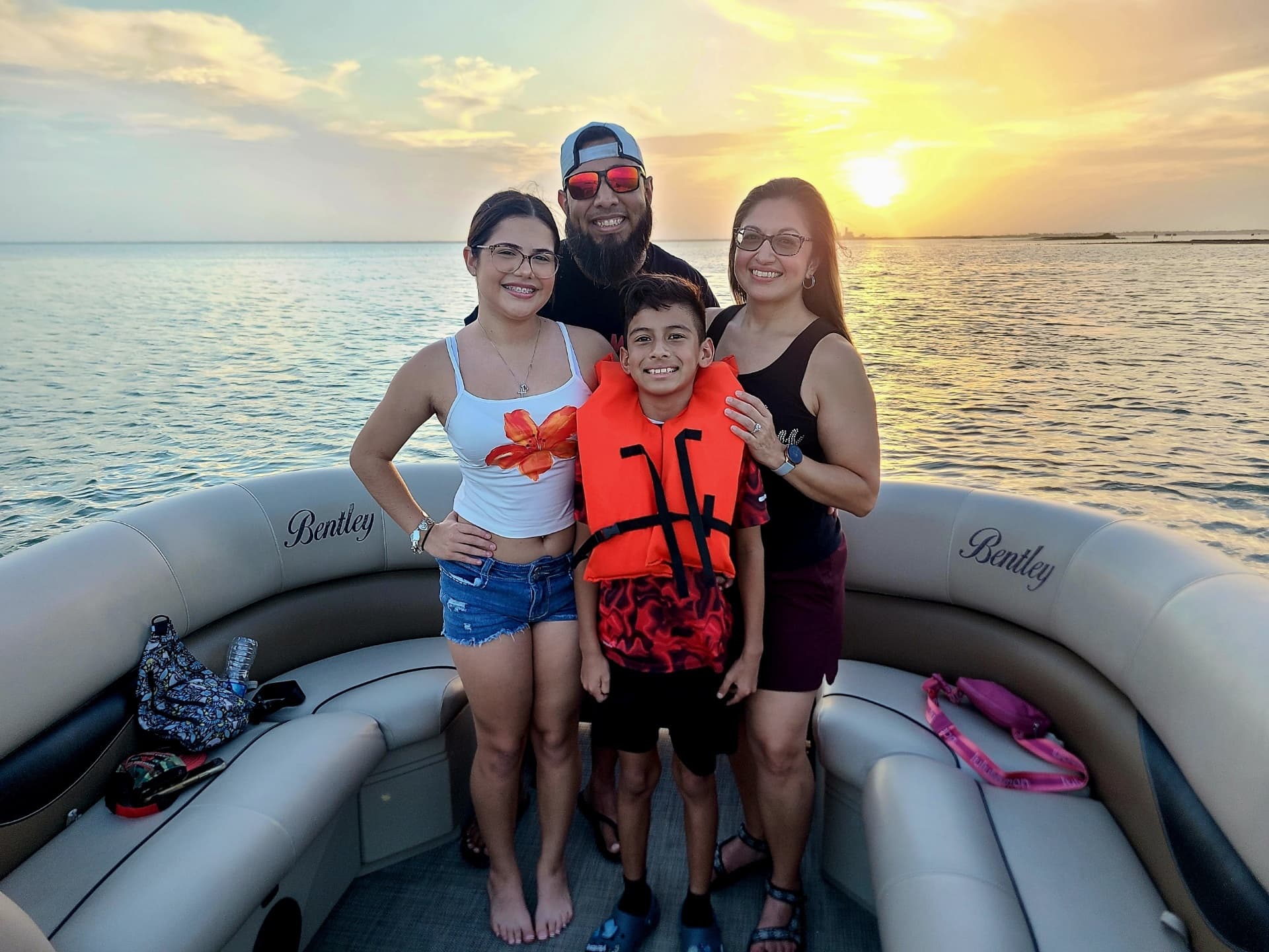 Family posing on pontoon boat during golden hour bay cruise