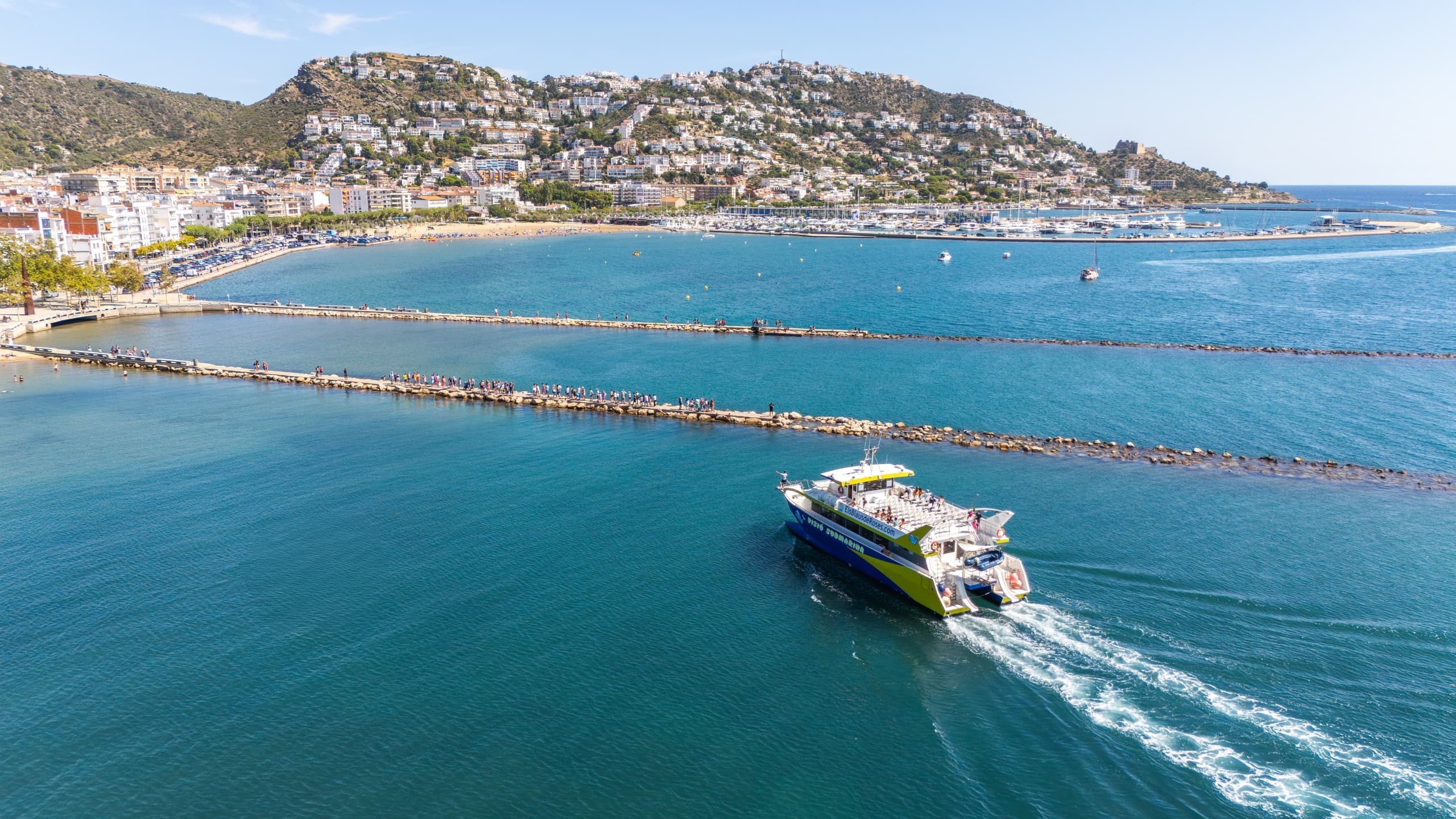 Passenger ferry cruising along coastal bay near seaside town