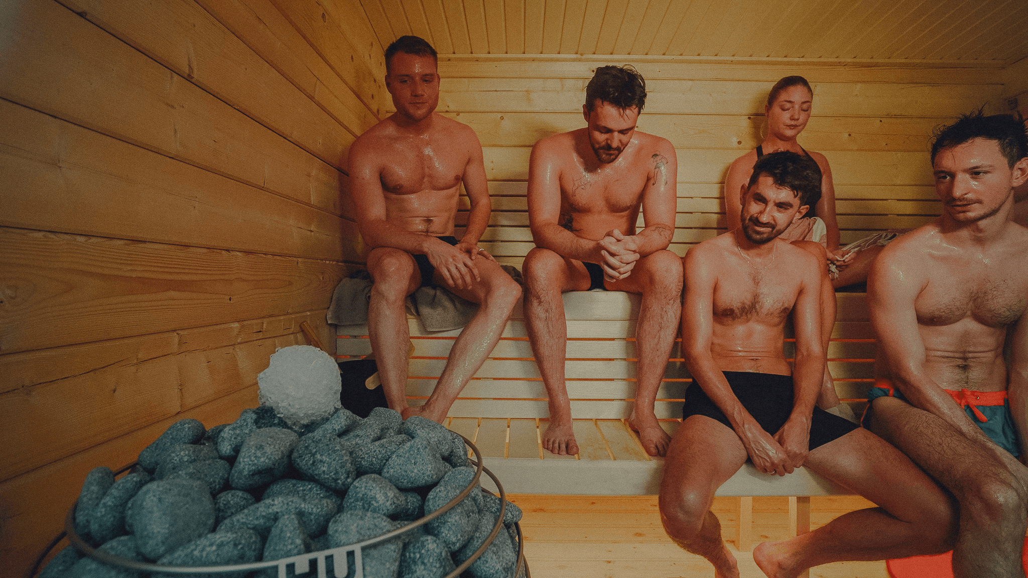 Men enjoying social sauna session in wooden cabin, Copenhagen