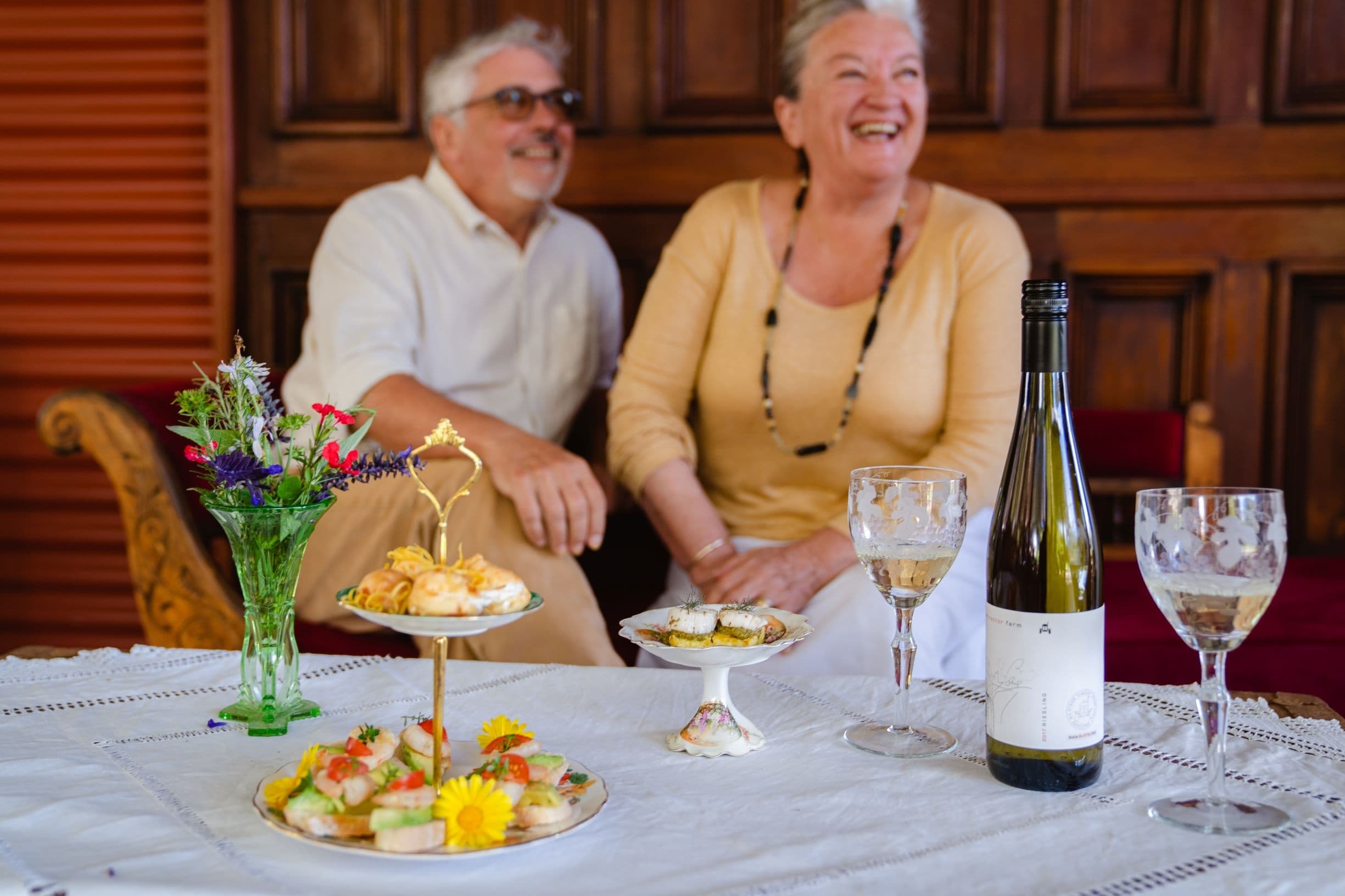 Couple enjoying wine and snacks at winery tasting table indoors