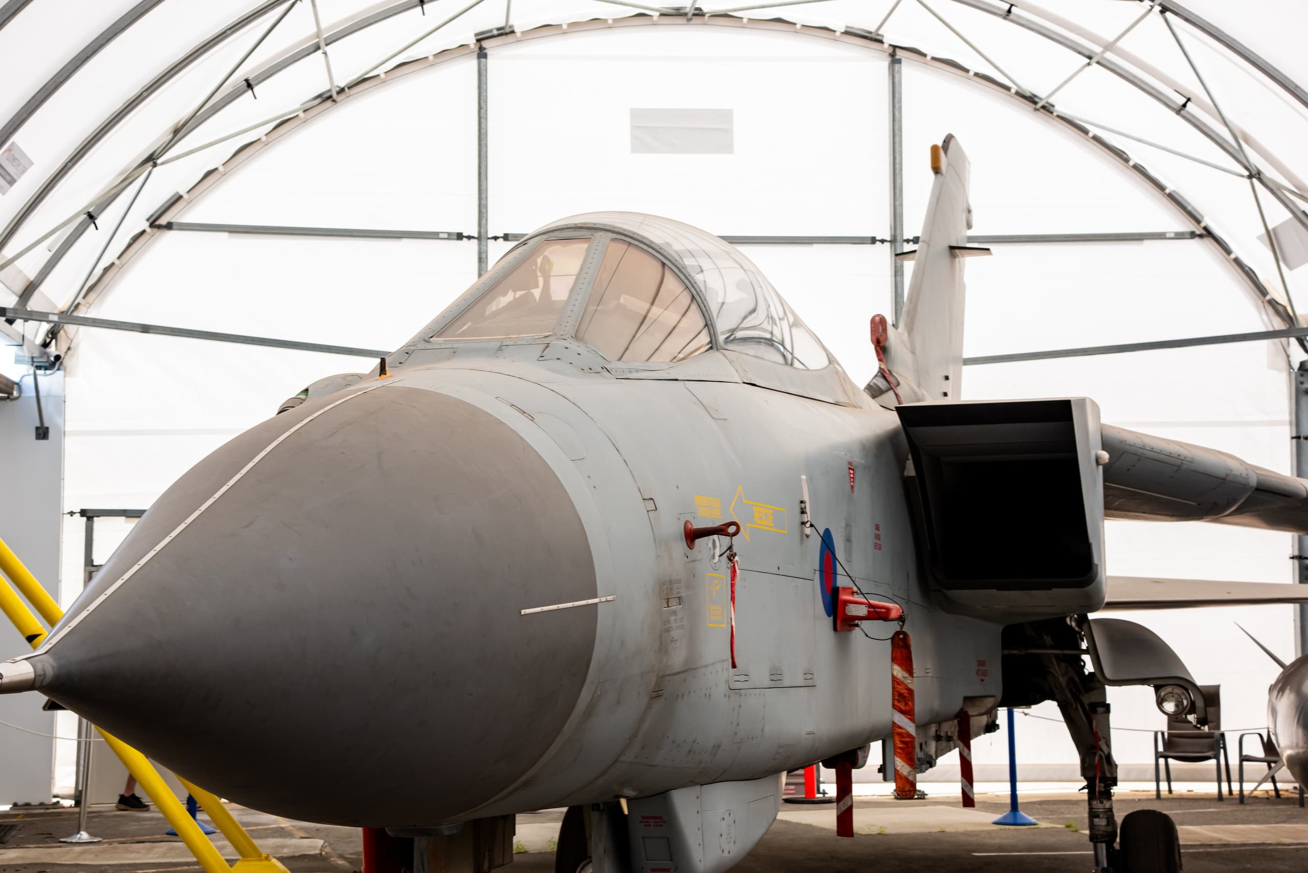 Close-up fighter jet nose inside aircraft museum hangar exhibit