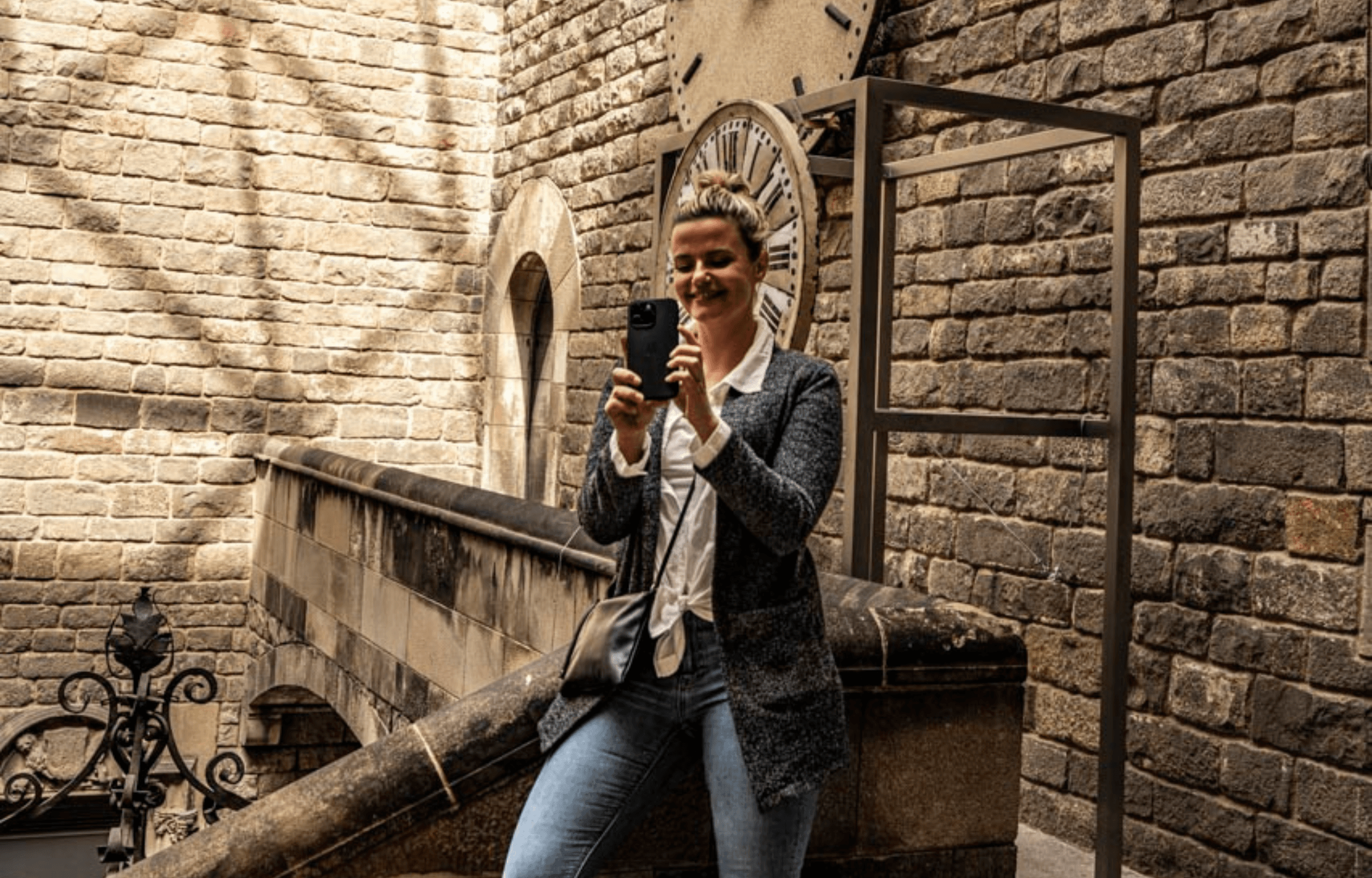 Woman photographing stone stairway in historic city courtyard