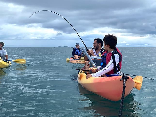 Kayakers fishing from sit-on-top kayaks on open ocean