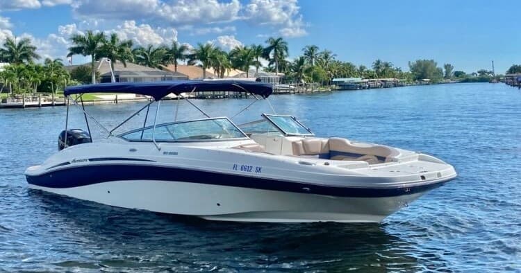Deck boat cruising tropical canal with palm-lined shoreline