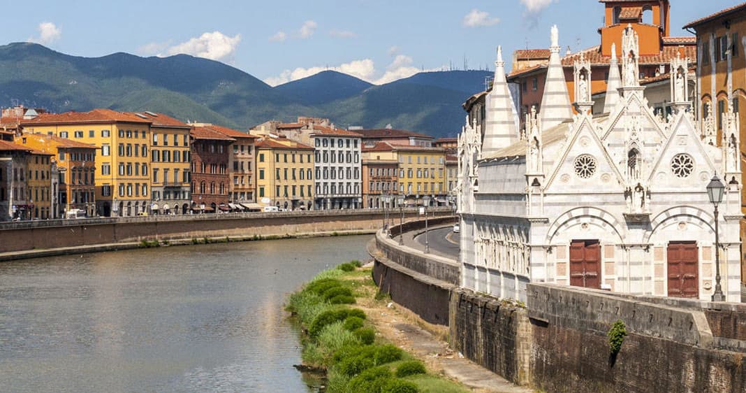 Arno River waterfront with colorful buildings in Pisa cityscape
