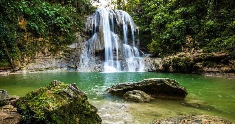 Waterfall swimming pool in lush Caribbean jungle, scenic falls